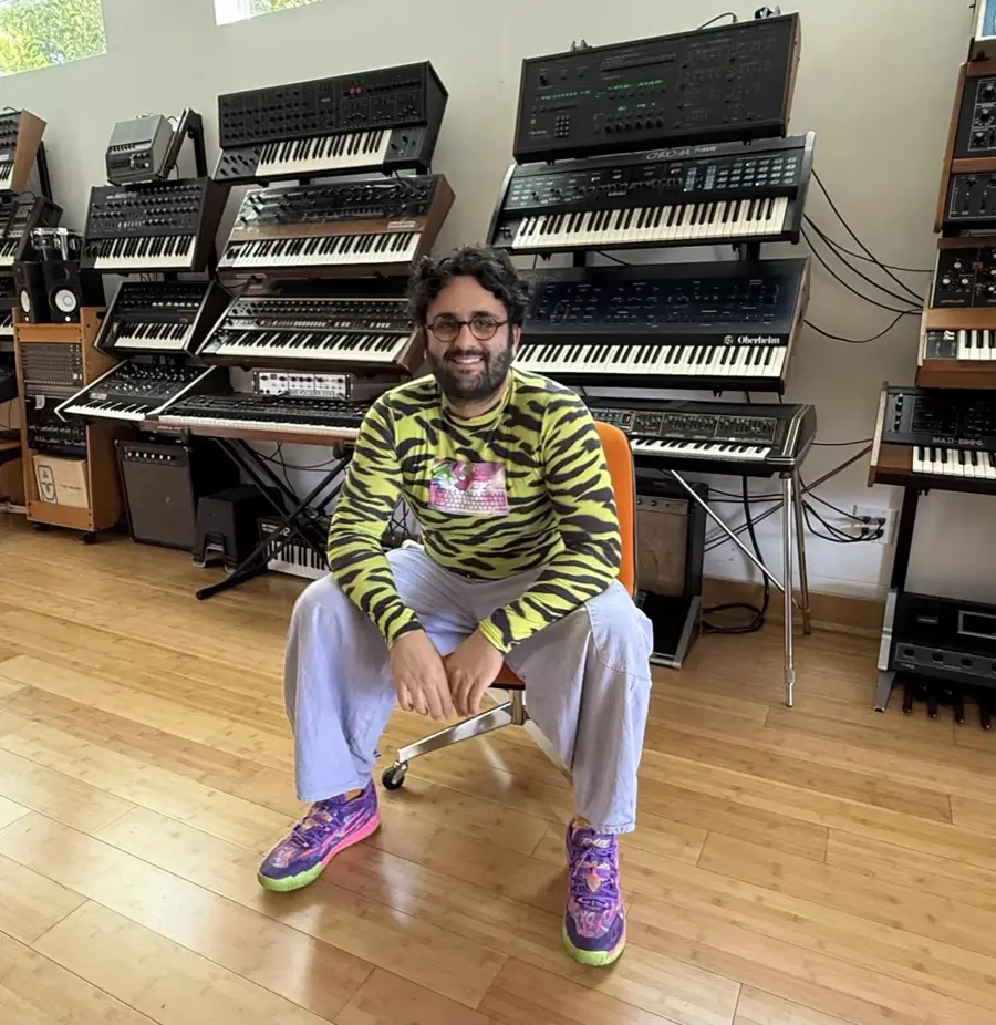 Daniel Jacob Molayem, seated in a room full of synthesisers